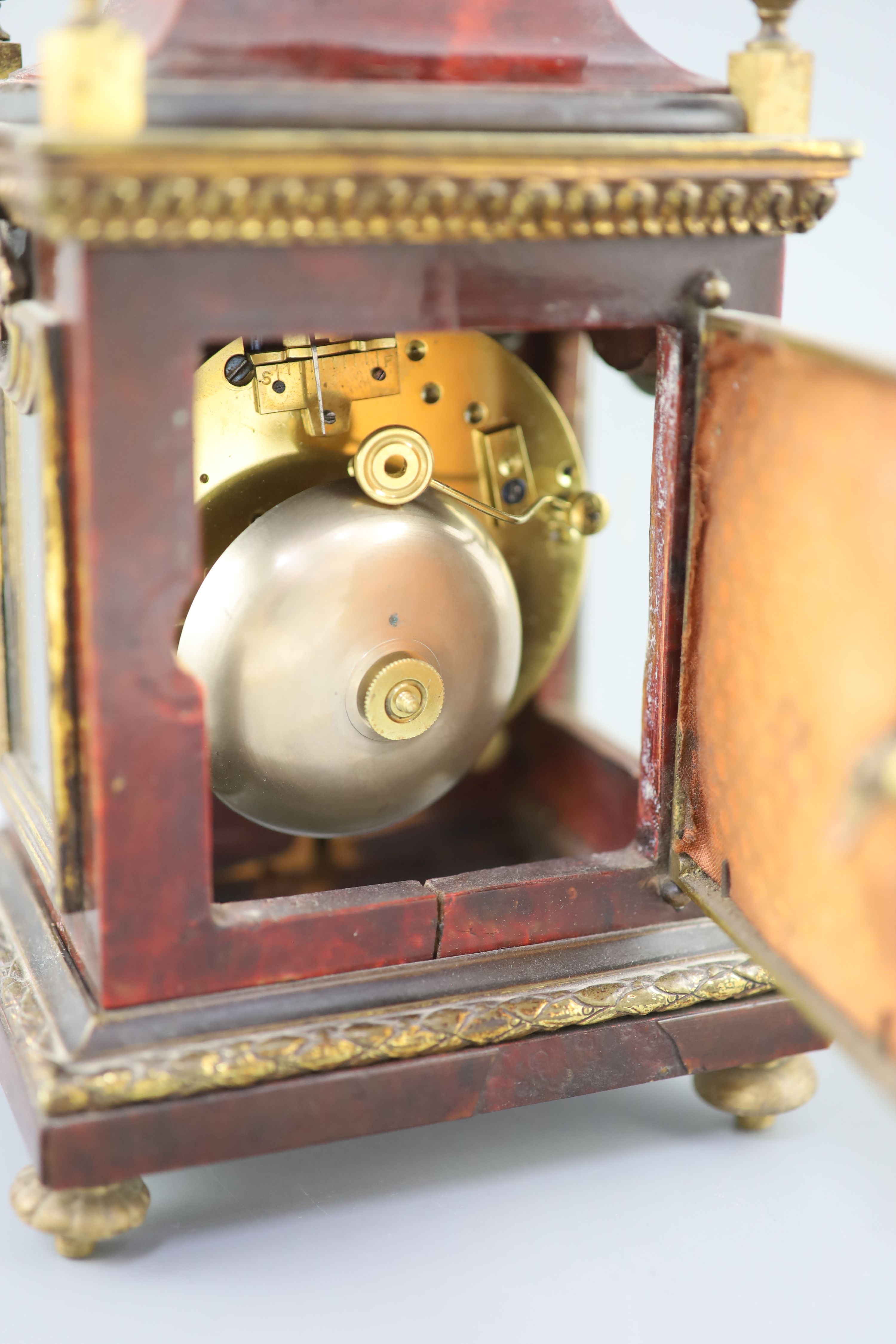 An early 20th century red tortoiseshell veneered mantel timepiece, height 8in.